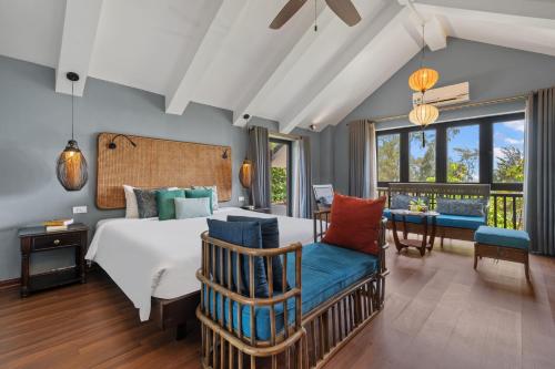 a bedroom with a bed and a chair and windows at Sweet Daisy Retreat in An Bàn (2)