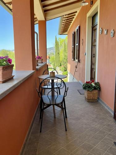 a patio with two chairs and a table on a porch at Villa Giulia apartment Assisi in Castelnuovo