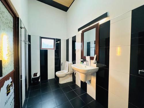 a bathroom with a white toilet and a sink at O2 Resort Welimada in Nugatalawa