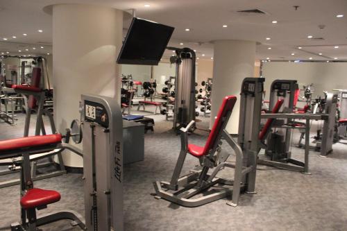 a gym with several tread machines and a flat screen tv at Executives Hotel - Olaya in Riyadh