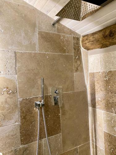a shower in a bathroom with a stone wall at Quinta de Ribas in Amarante