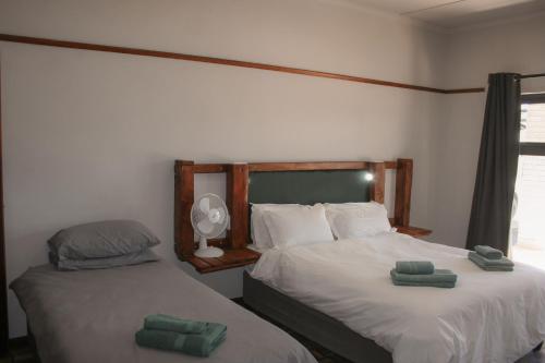two beds in a room with two green towels on them at Heydays B&B in Noupoort