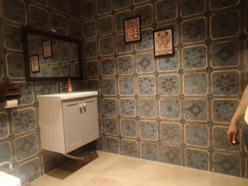 a bathroom with a urinal on a blue tiled wall at Amaiti pool villa in Bangalore