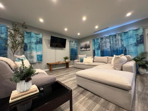 a living room with two couches and a flat screen tv at Spacious 3 bedroom unit with backyard and parking just 10 minutes from Rodeo Dr and attractions! in Los Angeles