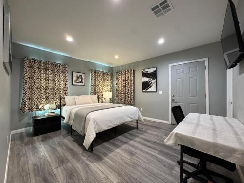 a bedroom with two beds and two tables in it at Spacious 3 bedroom unit with backyard and parking just 10 minutes from Rodeo Dr and attractions! in Los Angeles