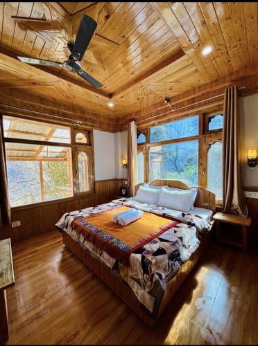 a bedroom with a large bed in a room with wooden ceilings at Cosy Crest in Banjār