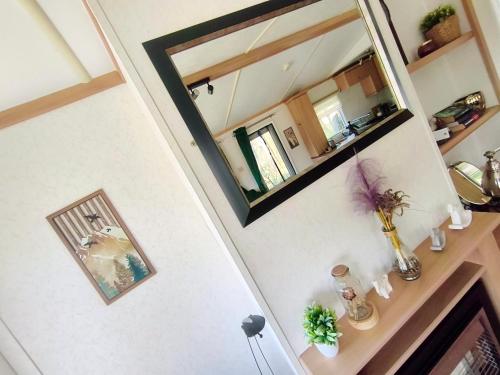 a mirror hanging on a wall next to a staircase at Odpocznij w Lesie in Biały Dwór