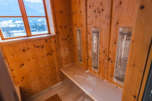 a room with wooden walls and a window and a bench at Hotel Walchseer Hof in Walchsee