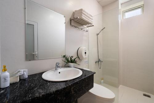 a bathroom with a sink and a toilet and a mirror at Gia Khanh Hotel in Da Lat