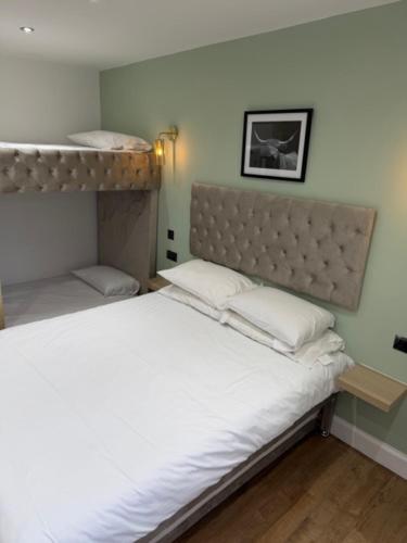 a bedroom with a bed with white sheets and pillows at west park hotel PVT ltd in Clydebank