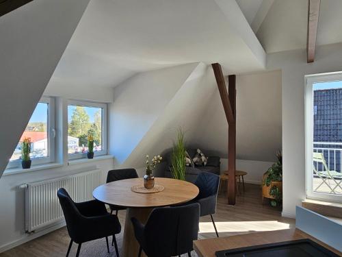 a living room with a table and chairs at Ferienwohnungen Stadtblick, 15208 - Nur für Urlaubsgäste! in Leer