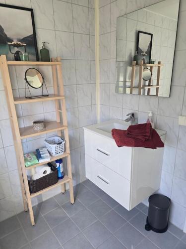 a bathroom with a sink and a mirror and a shelf at Cabin in Leirvåg in Leirvåg