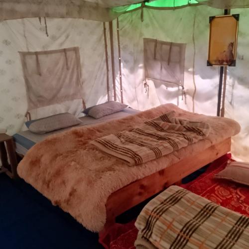 a bedroom with a bed in a tent at Shoolin camping in Jari