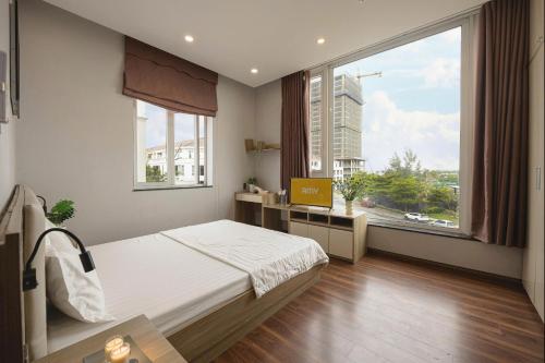 a bedroom with a bed and a large window at Amy Apartment Hue in Hue