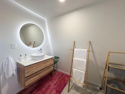 a bathroom with a sink and a mirror at Whangaroa Barn in Whangaroa