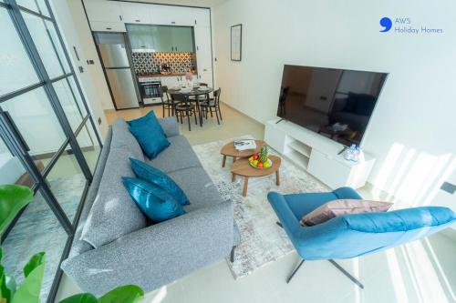 a living room with a blue couch and a television at AWS Holiday Homes - Stylish 2BR Apt at Dubai Hills in Dubai