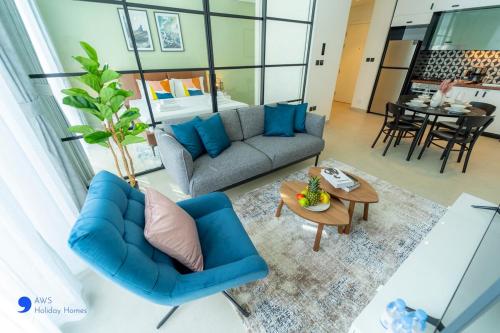 a living room with a blue couch and a table at AWS Holiday Homes - Stylish 2BR Apt at Dubai Hills in Dubai