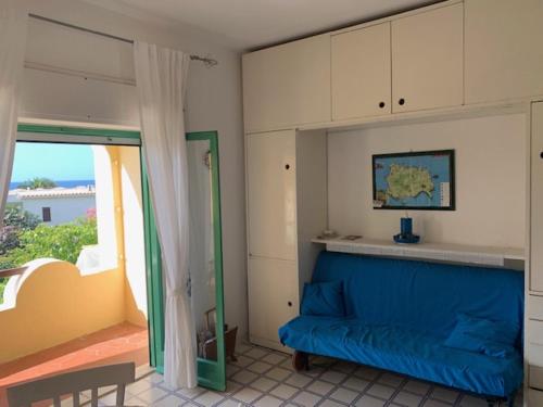 a living room with a blue couch and a window at Arcadia Case e Vacanze in Lacco Ameno