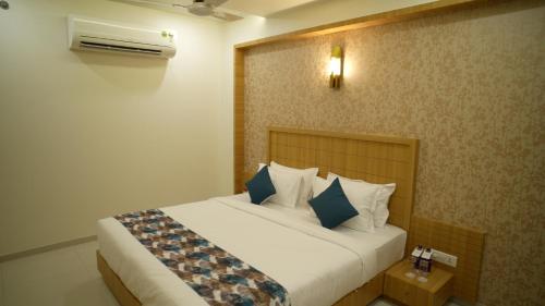 a bedroom with a bed with blue and white pillows at Hotel Roma Kristo in Dwarka