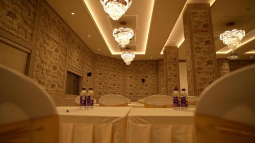 a room with a table and chairs and lights at Hotel Roma Kristo in Dwarka