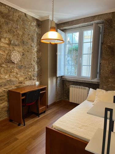 a bedroom with two beds and a desk and a desk at La Casa de la Plaza in Cee