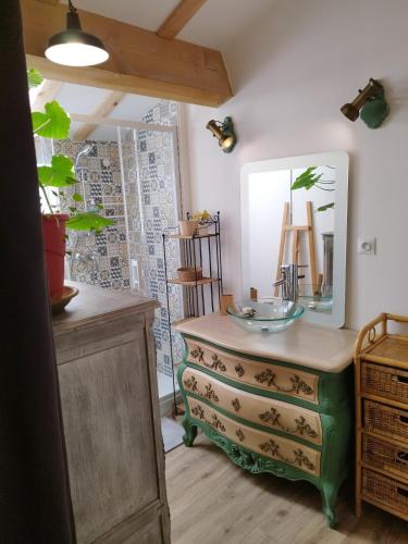 a bathroom with a dresser with a mirror on it at à 10 mn des Gorges de l'Ardèche in Bidon
