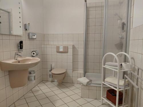 a bathroom with a sink and a toilet and a shower at Pension Villa Sophia in Sassnitz