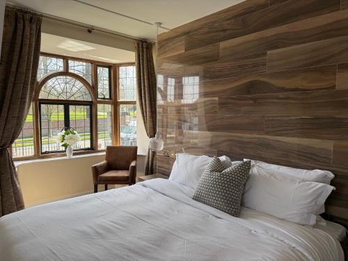 a bedroom with a large bed with a wooden wall at The Horse and Farrier Carlisle in Carlisle