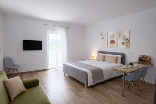 a bedroom with a bed and a table and a couch at Le Suite del Pastore, Monolocale con Terrazza Privata e Parcheggio Facile, vicino al Centro in Lecce
