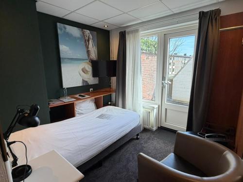 a hotel room with a bed and a window at Hotel Zee en Duin in Katwijk