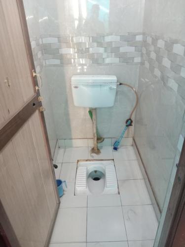 a small bathroom with a toilet in a stall at Shri Shyama seva kunj in Vrindāvan