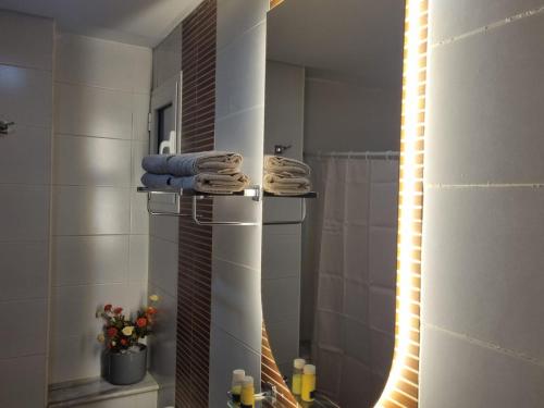 a bathroom with a mirror and a shower with towels at Chez-moi wiss in Sfax