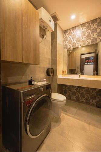 a small bathroom with a washer and a toilet at Amy Apartment Hue in Hue
