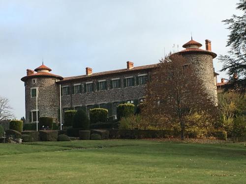 a large brick building with two towers on top of it at Domaine La Reveille in Dore-lʼÉglise