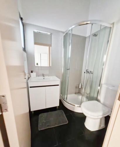 a bathroom with a shower and a toilet and a sink at Skyline Villas Room in Calheta