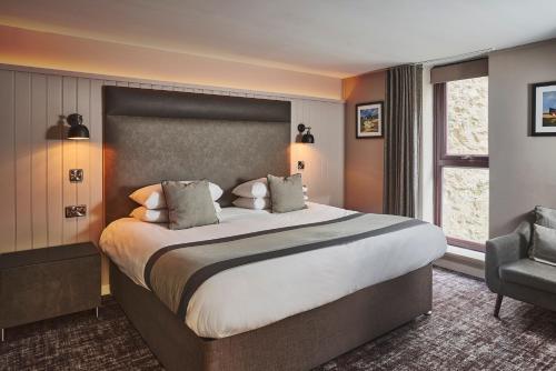 a hotel room with a large bed and a chair at The Ranald Hotel in Oban