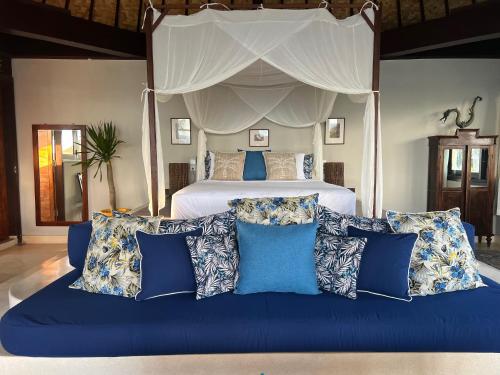 a bed with a blue couch in a bedroom at The Palms - Seraya Shores Retreat Bali in Seraya