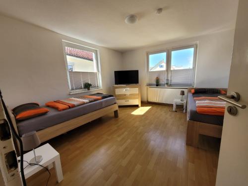 a bedroom with two beds and a tv and two windows at Charlotte II in Neustadt bei Coburg