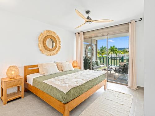 a bedroom with a bed and a balcony at Ocean Breeze, Fully Renovated Beachfront 2 bdr in Baie Nettle