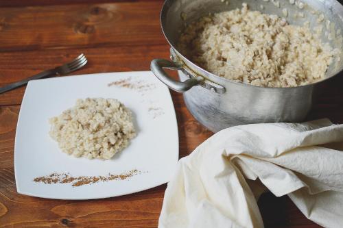 a bowl of rice on a plate next to a pot at Locanda Divinis in Cerea