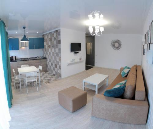 a living room with a couch and a table and a kitchen at Люкс с 2-мя спальнями в ЦЕНТРЕ in Mykolaiv