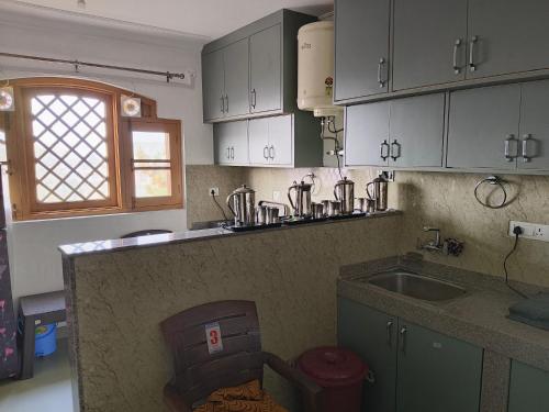 Eine Küche mit weißen Schränken, Spüle und Arbeitsplatte in der Unterkunft Bashaw Residency Top Rated In Srinagar Only 6 Kms from Srinagar International Airport And Only 5 Kms From Srinagar Railway Station in Srinagar