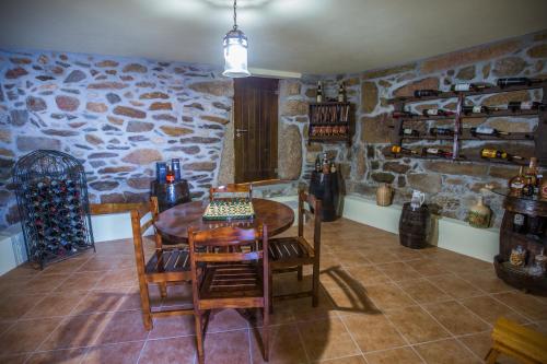 a room with a table and chairs and a stone wall at Cabanelas Country House - Casa do Afonso in Vale de Cambra