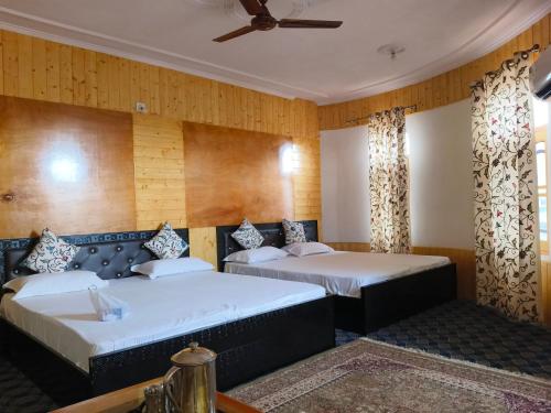 zwei Betten in einem Zimmer mit Holzwänden in der Unterkunft Bashaw Residency Top Rated In Srinagar Only 6 Kms from Srinagar International Airport And Only 5 Kms From Srinagar Railway Station in Srinagar