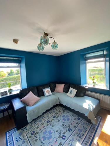 a living room with a couch and blue walls at The Cottage in Ramelton