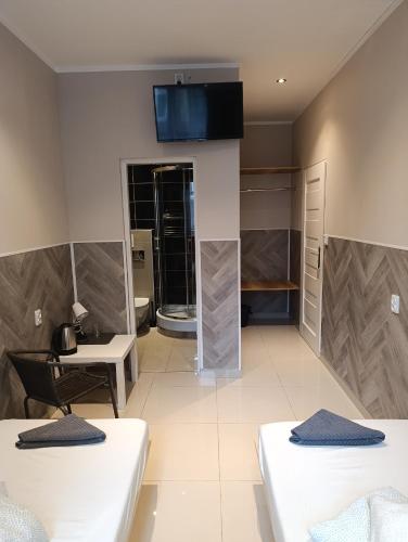 a room with two beds and a table and a desk at Rynek 7 in Katowice