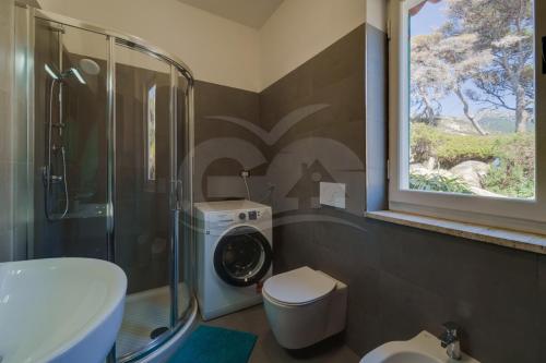 a bathroom with a washing machine next to a window at Casa Bianca - Goelba in Pomonte