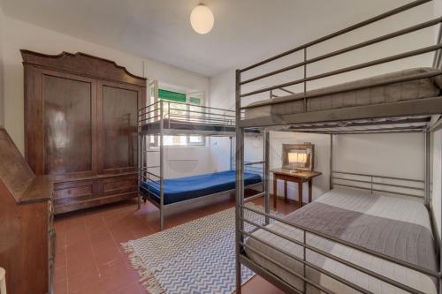 a bedroom with two bunk beds and a desk at Casa Bianca - Goelba in Pomonte