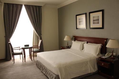 a hotel room with a bed and a table and chairs at Executives Hotel - Olaya in Riyadh