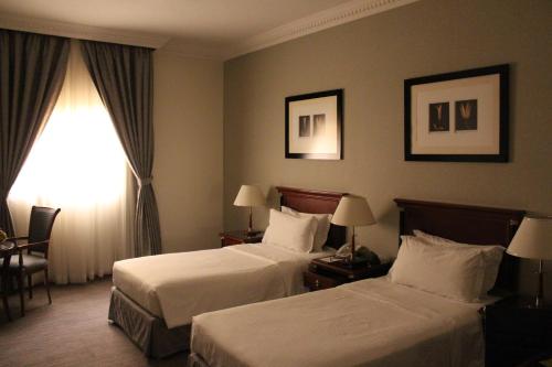 a hotel room with two beds and a window at Executives Hotel - Olaya in Riyadh